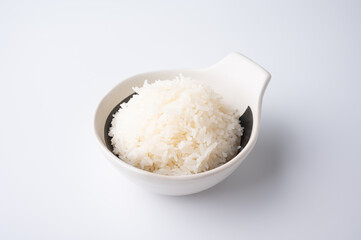 Bowl of boiled rice served on wooden table,