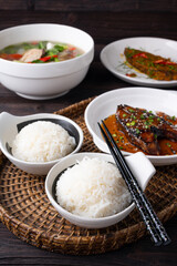 Bowl of boiled rice served on wooden table,