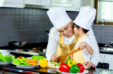 Happy family Asian man young father with son boy cooking healthy salad for the first time. first lesson and healthy lifestyle concept.