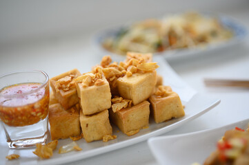 Deep fried tofu is cut into square balls on plate