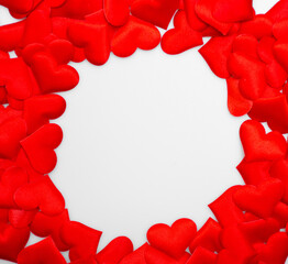 Many red textured hearts lie together in a round frame on a white background with space for text: background for Valentine's Day, Mother's day or International Women's Day