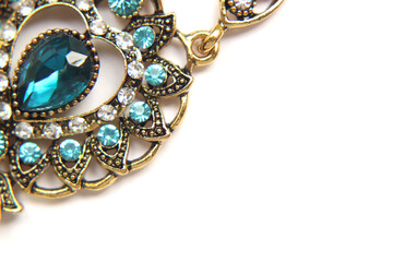 Oriental Turkish women's jewelry with blue gem on a white background