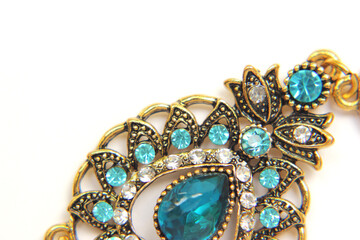 Oriental Turkish women's jewelry with blue gem on a white background