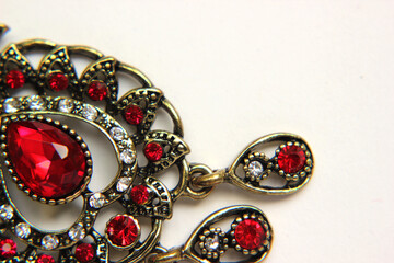 Oriental Turkish women's jewelry with red gem on a white background