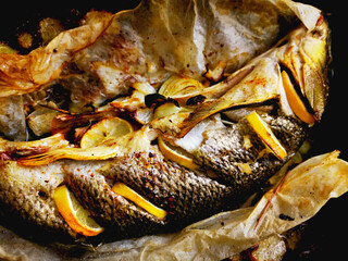 Roasted fish Barbel in a pan with onions and spices.