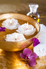 Bowl with water, candles and  towel. Spa, wellness or body care concept.