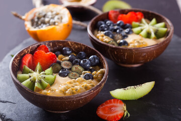 Healthy breakfast with yogurt, exotic fruits and berries in a bowl.