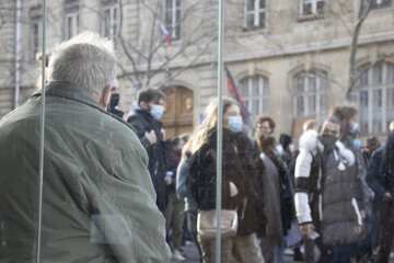 Une personne âgé regarde passer la manifestation étudiante pour la réouverture des universités...