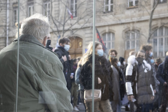 Une personne &acirc;g&eacute; regarde passer la manifestation &eacute;tudiante pour la r&eacute;ouverture des universit&eacute;s et l'augmentation des aides suite &agrave; la crise sanitaire, le long du jardin du Luxembourg.