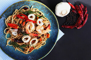 Spaghetti spicy seafood on black background.