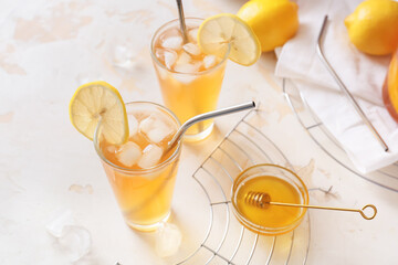 Glasses of tasty ice tea on light background
