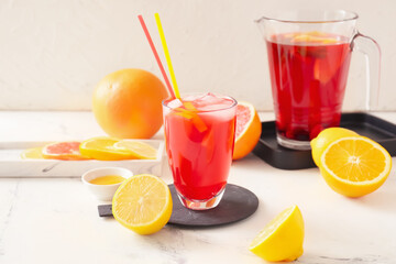 Glass of tasty ice tea on light background