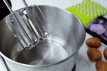 Electric mixer with whisk making dough for cake.