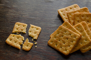 Groceries, snacks, food. Stack of Salted Crunchy Crackers on a wooden table.