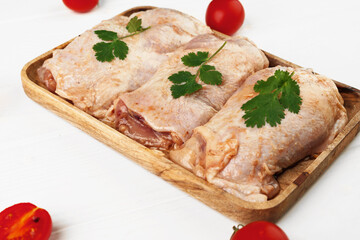 Raw marinated chicken breasts on wooden board