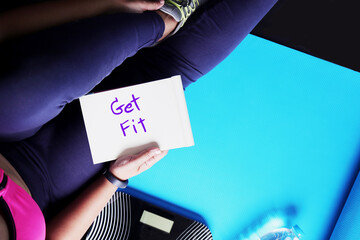 Top view of Healthy Lifestyle concept, Woman sitting on yoga mat with Get fit text.