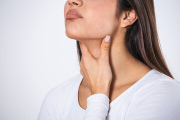 Young beautiful woman suffering from pain in throat, touching inflamed zone on her neck, cropped, empty space, sore throat
