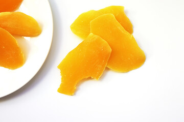 Sliced dried mango in white dish.
