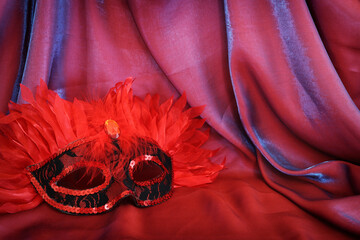 Photo of elegant and delicate Venetian mask over red silk background