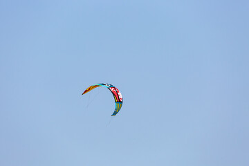 Wing of paraglider on empty blue sky