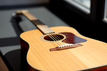 Fototapeta premium leisure, music and musical instruments concept - close up of acoustic guitar on window sill