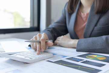 Accounting businesswomen are calculating income-expenditure and analyzing real estate investment data, Dedicated to the progress and growth of the company, Financial and tax systems concept.