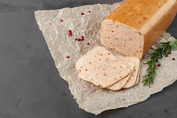 Meat sausage on parchment on gray background