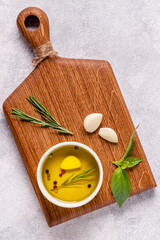 Herbs and condiments on light stone background.