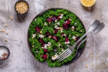 Healthy raw kale and beetroot salad with feta cheese and pine nut.