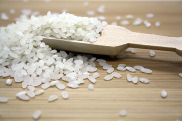 Obraz na płótnie Canvas White rice for pilaf on a wooden background.