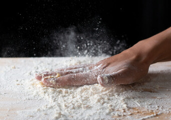 wave of hands with flour on a black background