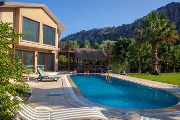 Panoramic view of luxury villa with swimming pool and tropical garden.