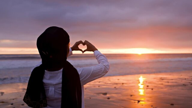 Somali-American woman watching the sunset at a beach in Malibut.