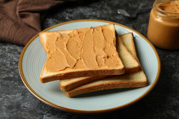 Concept of breakfast with peanut butter toast on black smokey table
