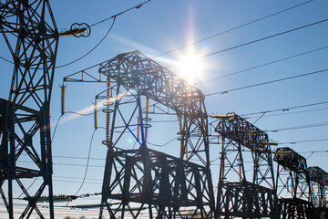 Wires against the background of the sun. High Voltage electric Pole, wiring electric power on steel...