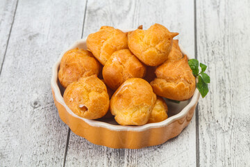 Sweet tasty profiteroles heap in the bowl