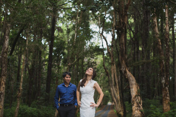 Naklejka na ściany i meble Walking the young bride and groom in the woods