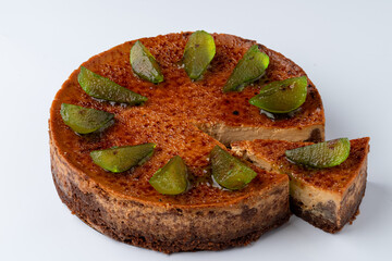 Wet fruit cake with sugared fruits on top, white background