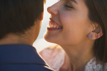 Fototapeta premium Bride and groom kisses tenderly. Sexy kissing stylish couple of lovers close up portrait
