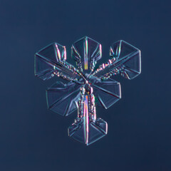 Snowflake on smooth gradient background. Macro photo of real snow crystal on glass surface. This is small snowflake with unusual pattern.