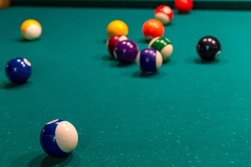 Foto op Plexiglas Sports game of billiards on a green cloth. Multi-colored billiard balls with numbers on a pool table © kosmos111