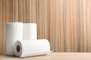 Rolls of paper tissues on wooden table. Space for text