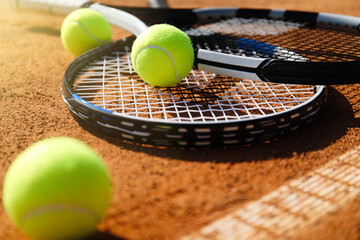 Tennis balls and rackets on clay court, closeup