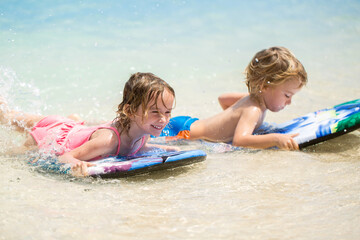 Twins brother and sister to have fun with surfing in the ocean