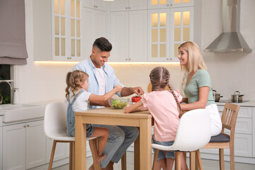 Obraz premium Happy family cooking together at table in modern kitchen