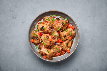 Dim Sum Pork Spare Ribs or Pai Guat in gray bowl on dark concrete table top. Chinese cantonese cuisine steamed spareribs dish with black soybeans. Asian food. Top view