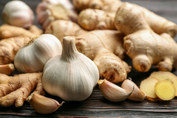 Ginger and garlic on black wooden table, closeup. Natural cold remedies