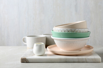 Different dishware and marble board on table