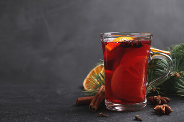 Tasty aromatic mulled wine on black table, space for text