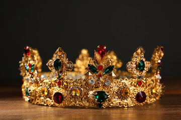Beautiful golden crown with gems on wooden table. Fantasy item © New Africa